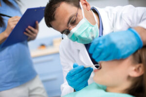 Tannlege undersøker tennene til en pasient.